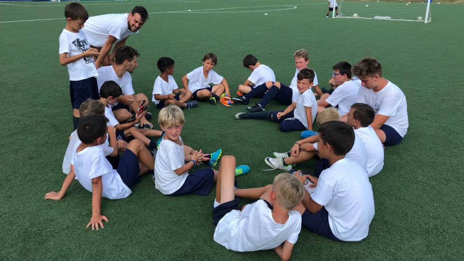 Istruttore della Vibe Ronchese a colloquio con i ragazzi della scuola calcio sul campo sintetico