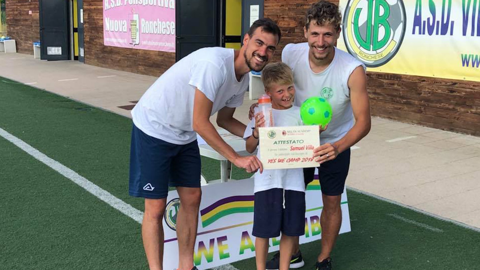 Istruttore che consegna l'attestato di partecipazione a un giovane atleta sul campo